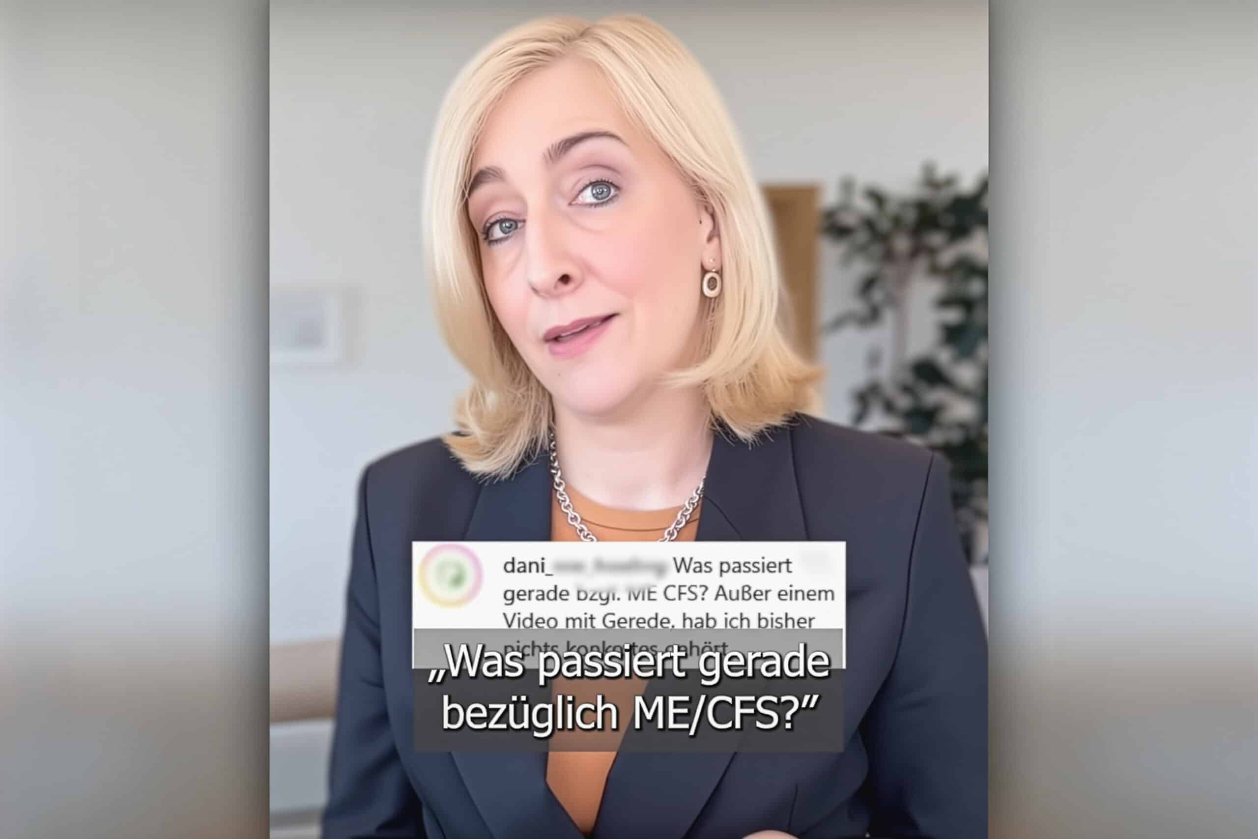 Eine Frau mit blonden Haaren und einem Blazer spricht in einem gut beleuchteten Raum. Der eingeblendete Text auf Deutsch lautet: "Was passiert gerade bezüglich ME/CFS?" Ein verschwommener Kommentar ist ebenfalls auf dem Bild zu sehen.